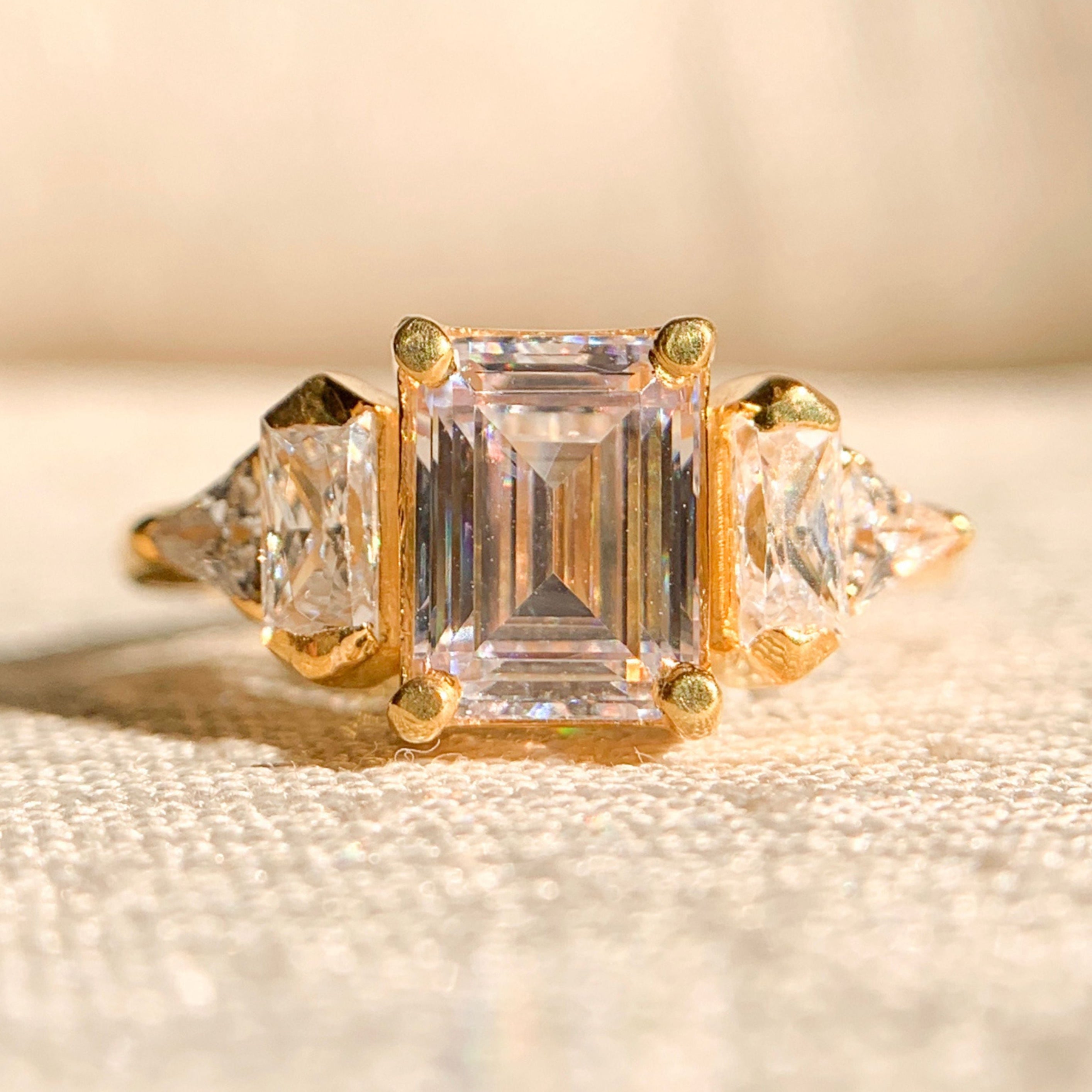 Emerald cut moissanite three stone engagement ring in white gold